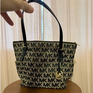 MK canvas handbag with leather straps and gold accents.